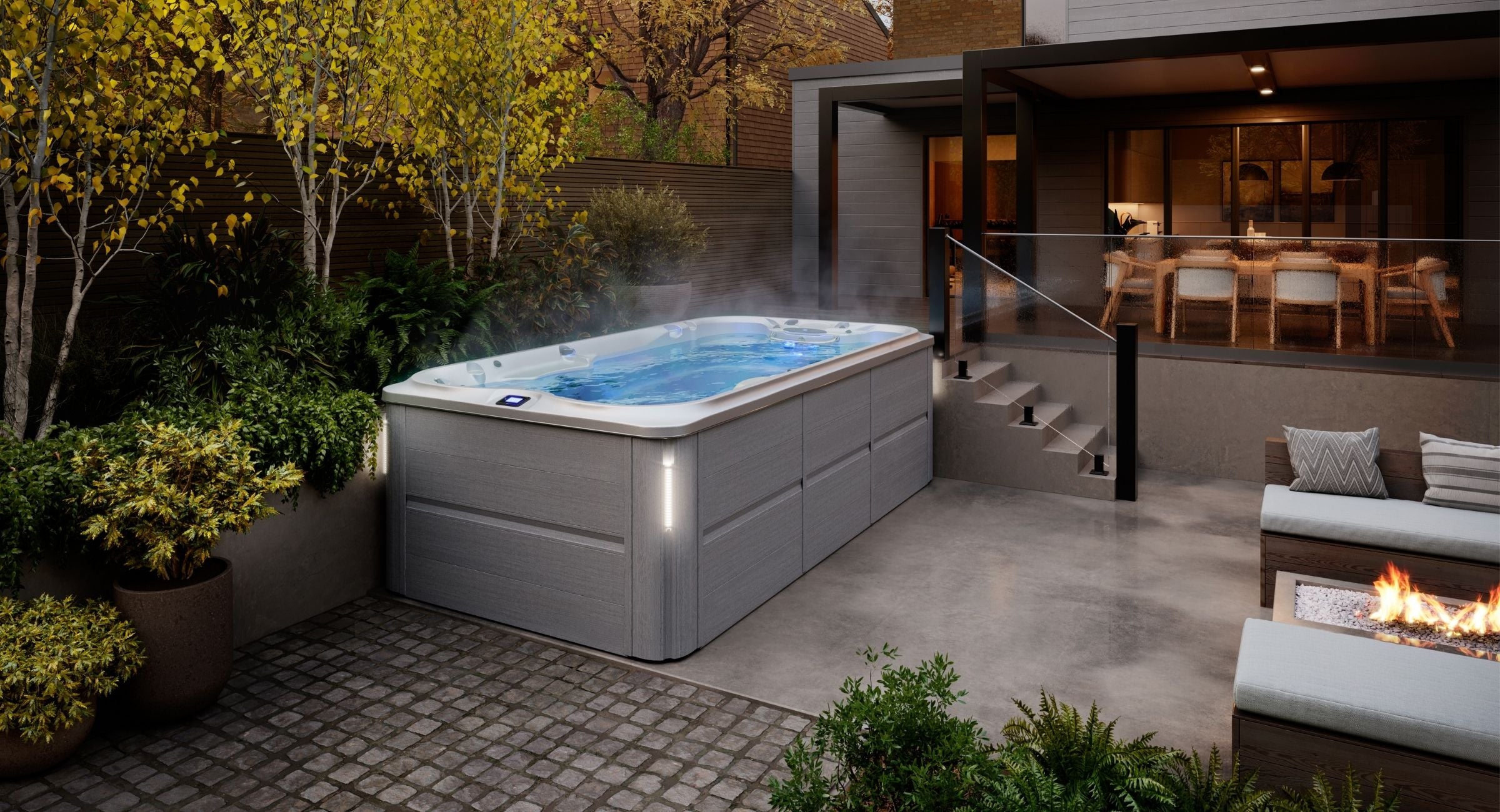 Swim spa in a backyard setting with outdoor furniture and fire pit.
