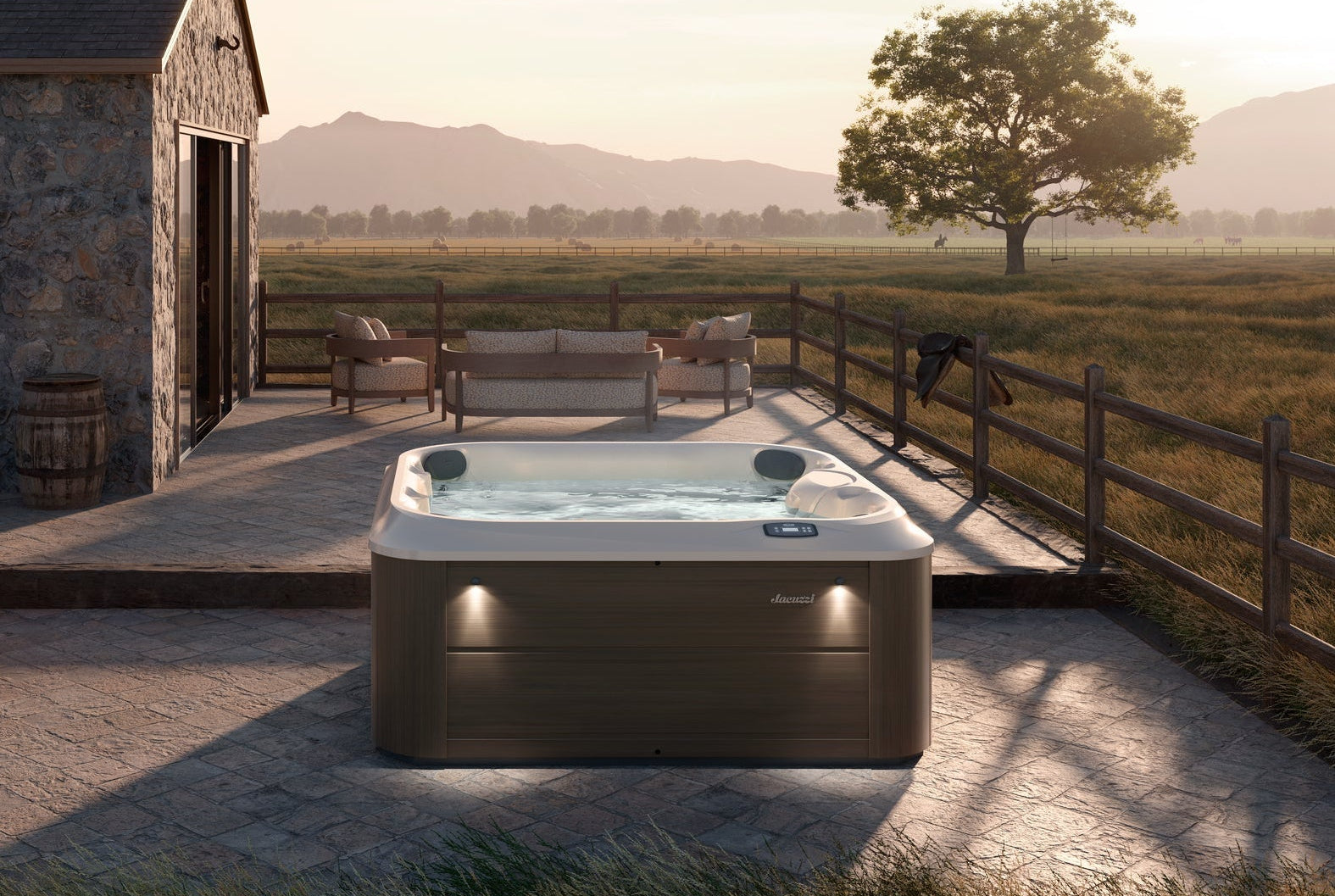 Outdoor hot tub on a patio with a scenic view of mountains and fields.
